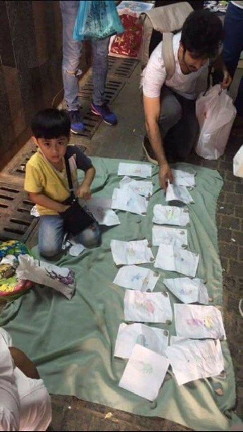 Muslim child is selling his simple drawings