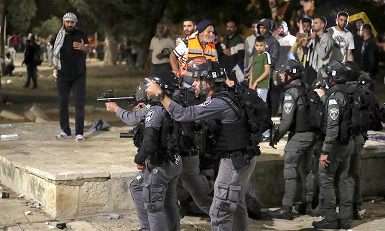 Israeli policemen aim their weapons at protesters during clashes with Palestinians at Al Aqsa Mosque
