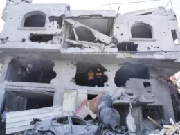 Palestinians stand inside the building destroyed in an Israeli airstrike in Nuseirat camp in the central Gaza Strip