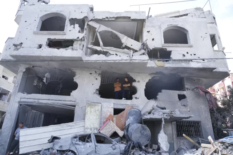 Palestinians stand inside the building destroyed in an Israeli airstrike in Nuseirat camp in the central Gaza Strip