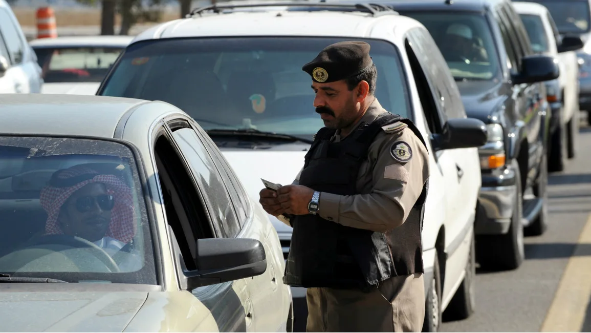 Saudi policeman checking permits