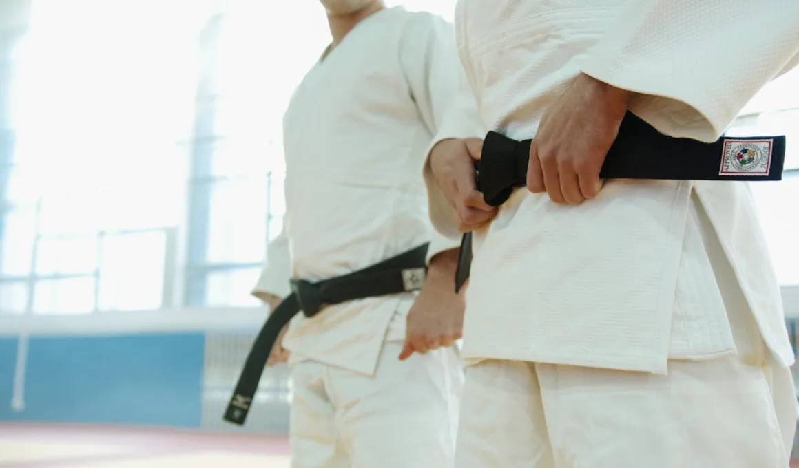 Close Up Shot of Two People Wearing Karategi and Black Belt