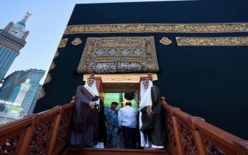 saudi man standing at the gate of kaaba