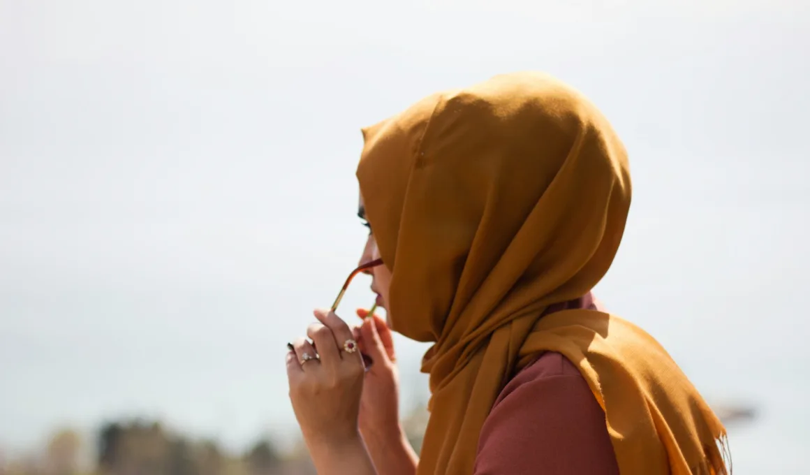 women in brown headdress putting eyeglasses in tilt shift photography