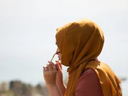 women in brown headdress putting eyeglasses in tilt shift photography