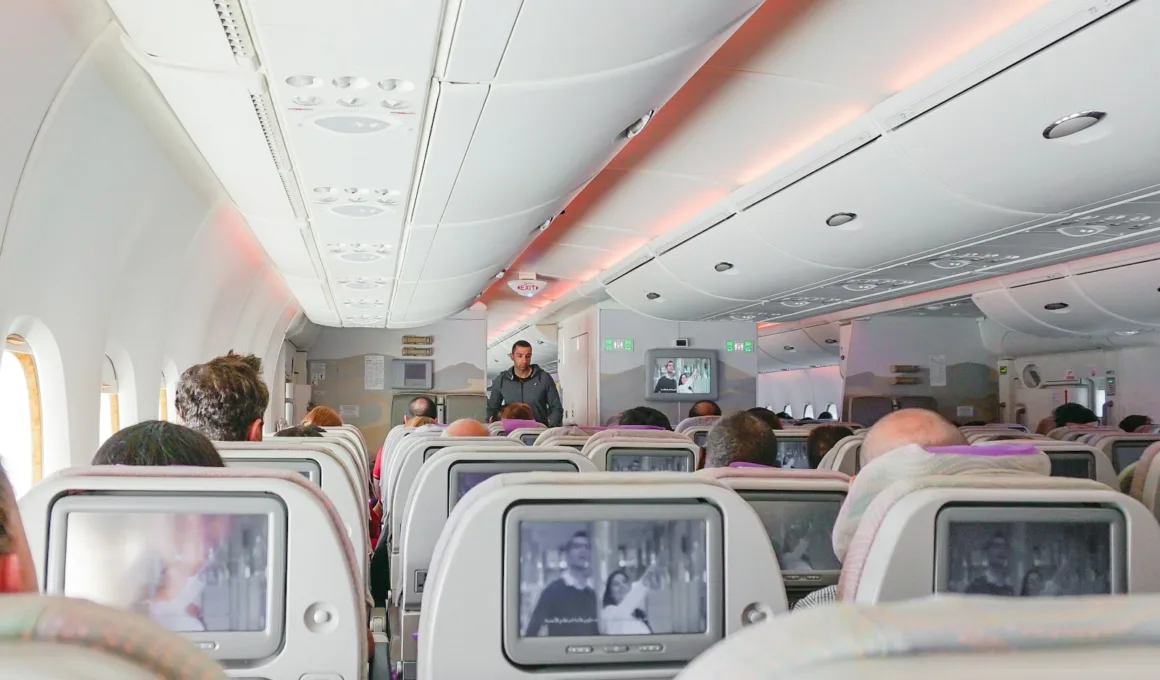 man walking down the aisle of airplane