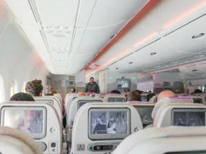 man walking down the aisle of airplane