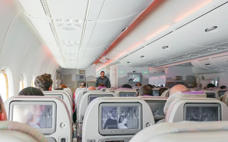 man walking down the aisle of airplane