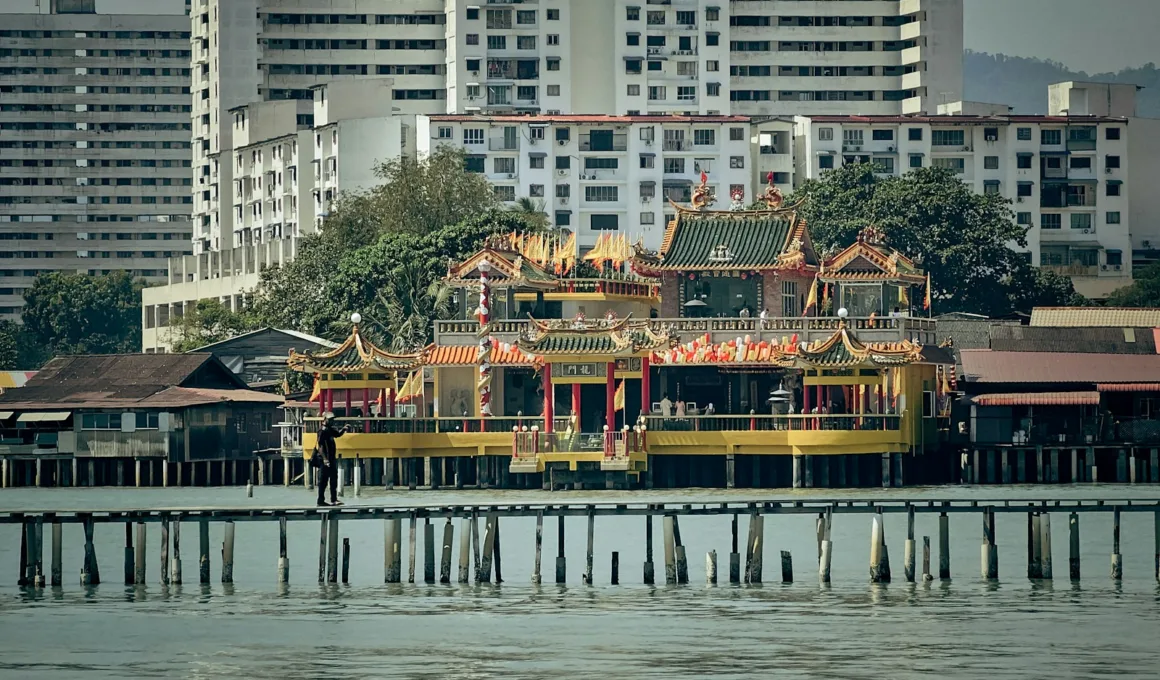 a pier with some buildings in the background IN PENANG