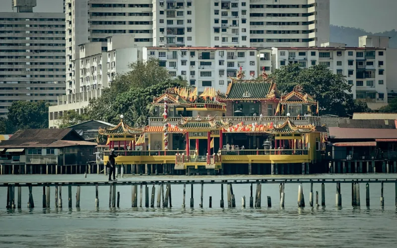 a pier with some buildings in the background IN PENANG