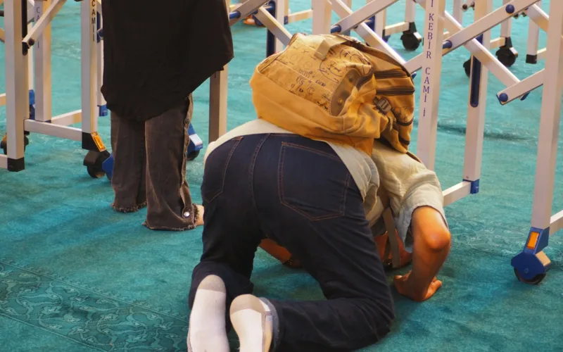 a man kneeling on the ground with a backpack on his head fart