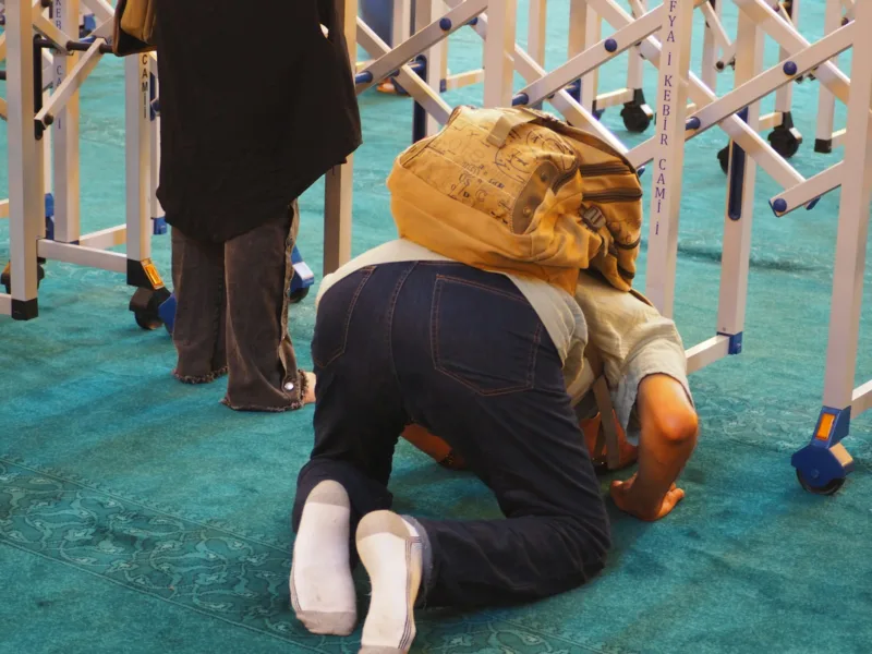 a man kneeling on the ground with a backpack on his head fart