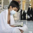 young pilgrim reciting quran in mataf masjid al haram