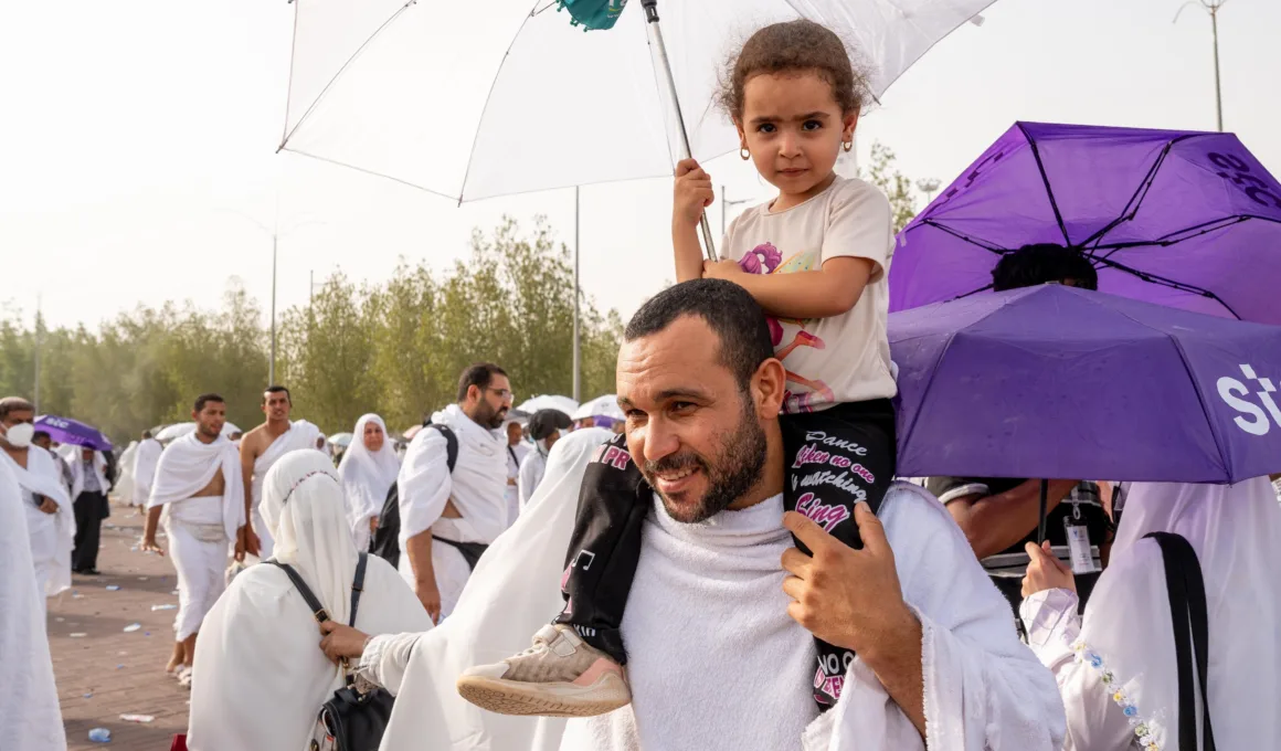 hajj pilgrims 2024 with kid on shoulders