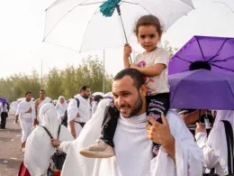 hajj pilgrims 2024 with kid on shoulders
