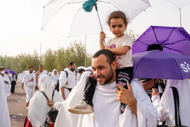 hajj pilgrims 2024 with kid on shoulders