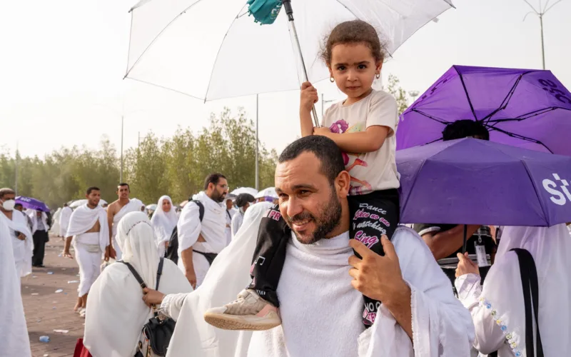hajj pilgrims 2024 with kid on shoulders