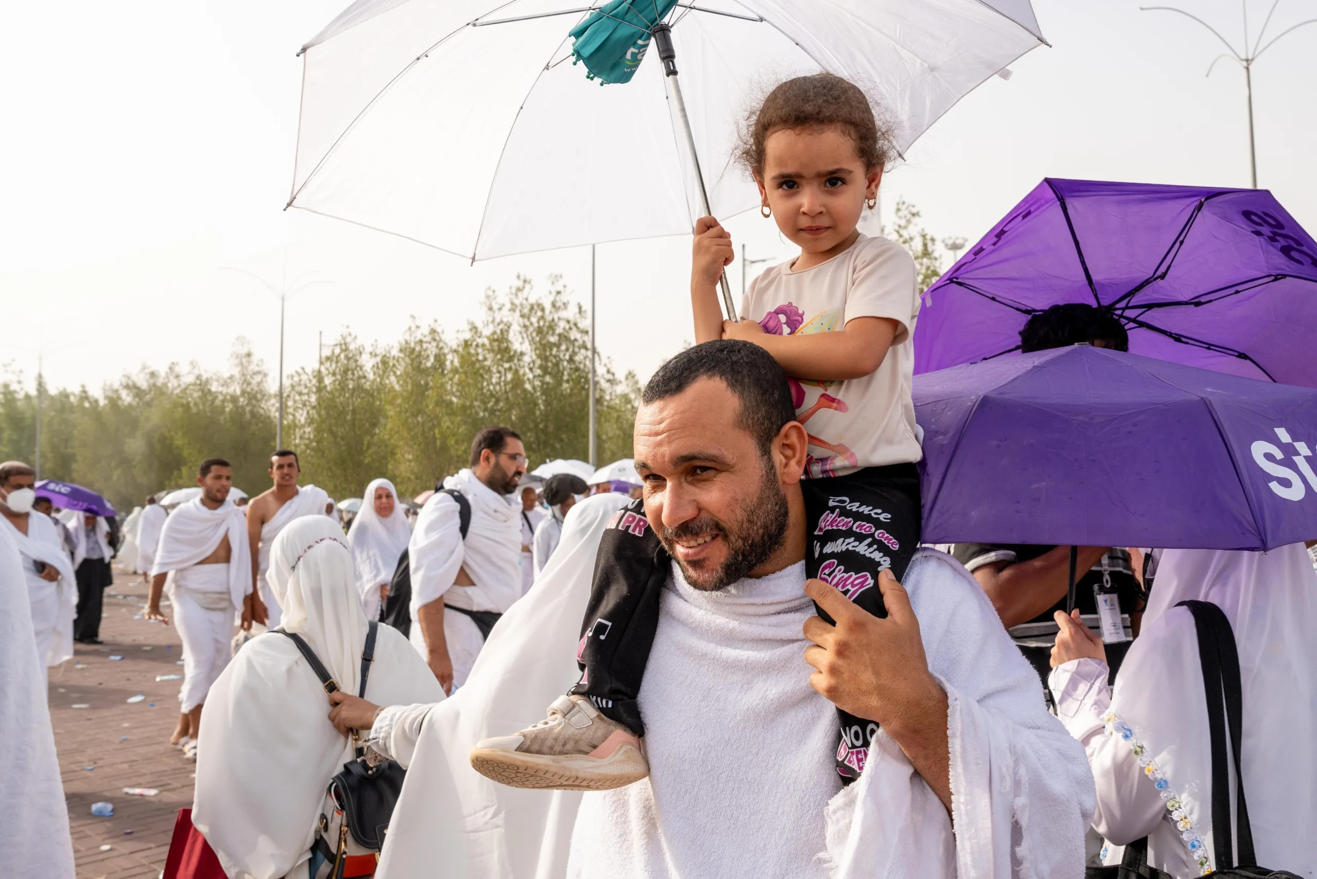 hajj pilgrims 2024 with kid on shoulders