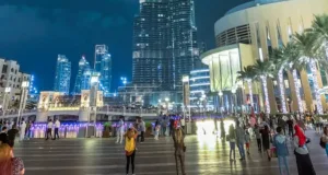 people standing near high rise building during night time