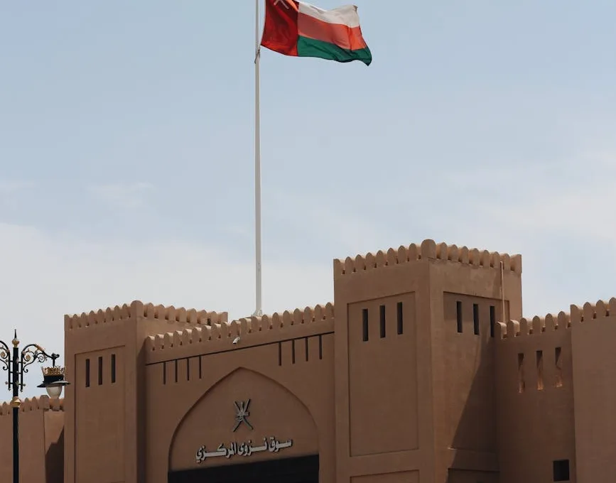 omani flag flying over historic fort gate