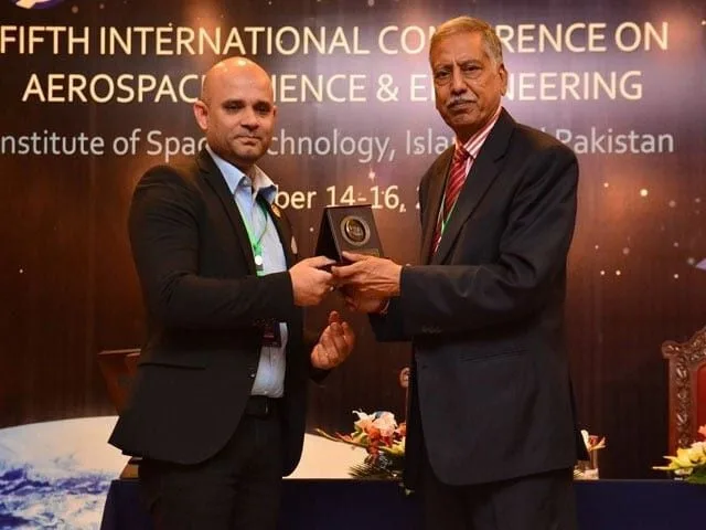 Dr. Nozair Khawaja (L) accepts award in Islamabad