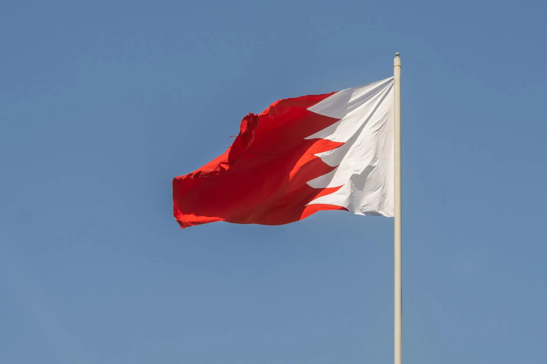 bahrain national flag against clear blue sky
