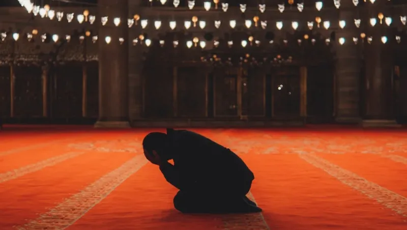 man praying in mosque