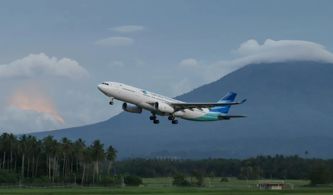 Garuda Indonesia airliner in flight over runway