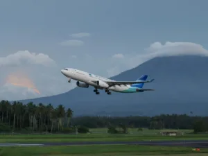 Garuda Indonesia airliner in flight over runway