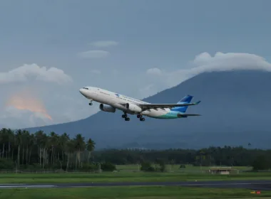 Garuda Indonesia airliner in flight over runway
