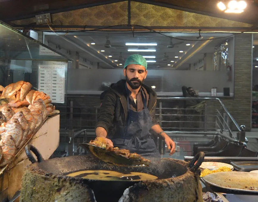 street vendor cooking fish at indoor market