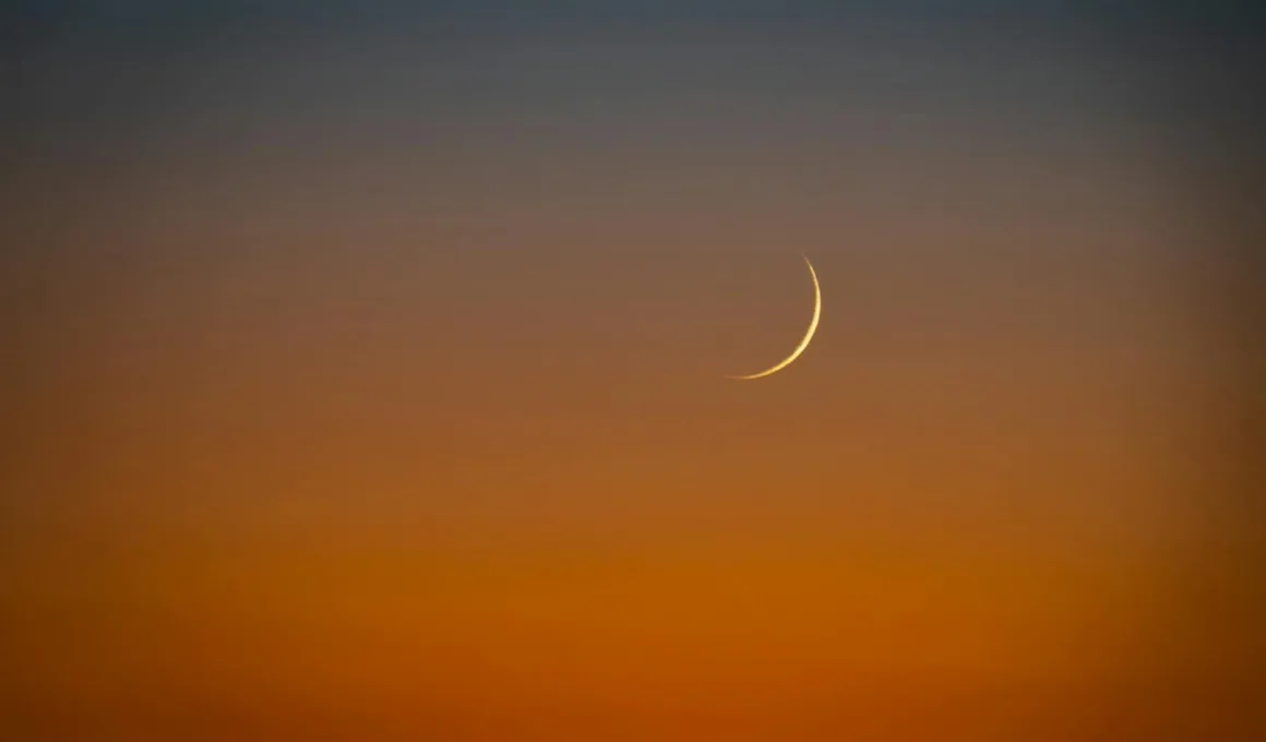 crescent moon over vibrant sunset sky