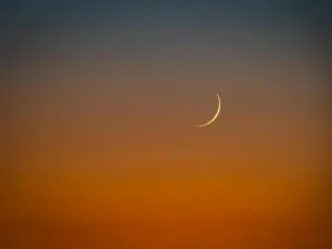 crescent moon over vibrant sunset sky