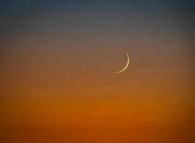 crescent moon over vibrant sunset sky