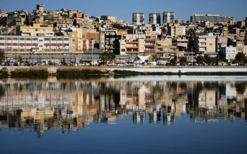 cityscape reflection on calm water with blue sky